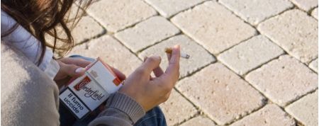 Rapaza fumando un cigarro na rúa